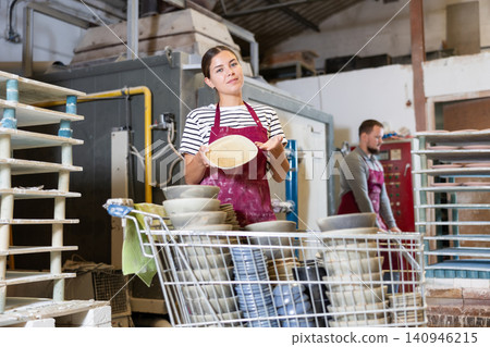 Young woman posing with ceramic dishes Young woman posing with ceramic dishes 140946215