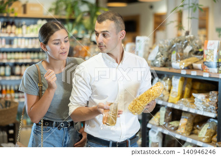 Young couple buying pasta in large grocery store Young couple buying pasta in large grocery store 140946246