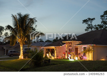 Christmas lights and illuminated ornaments on Florida front yard. Warm New Year celebration in tropical climate. Christmas lights and illuminated ornaments on Florida front yard. Warm New Year celebration in tropical climate. 140946263