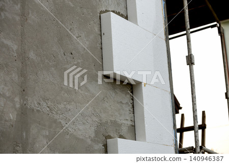 Close-up detail of plastered house wall with rigid styrofoam insulation. Modern technology, construction, renovation, energy saving, alternative for mineral wool, warm comfortable house concept. Close-up detail of plastered house wall with rigid styrofoam insulation. Modern technology, construction, renovation, energy saving, alternative for mineral wool, warm comfortable house concept. 140946387