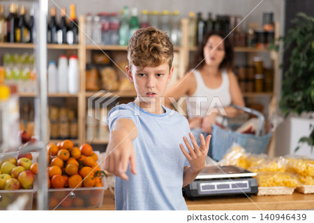 Disgruntled boy asks mom to buy at grocery store Disgruntled boy asks mom to buy at grocery store 140946439