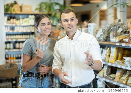 Couple exploring with interest shelves at organic foods store Couple exploring with interest shelves at organic foods store 140946453