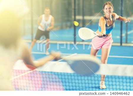 Young woman and man playing tennis against woman Young woman and man playing tennis against woman 140946462
