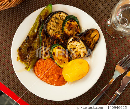 Grilled vegetables prepared according to Catalan traditions, served with romesco sauce closeup 140946625