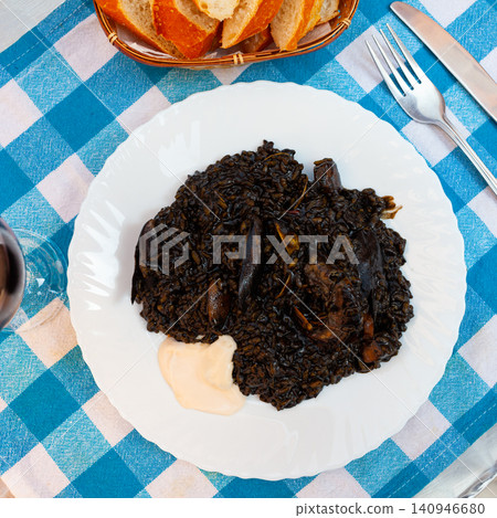 Arroz negro - spanish recipe, black paella with cuttlefish on plate Arroz negro - spanish recipe, black paella with cuttlefish on plate 140946680