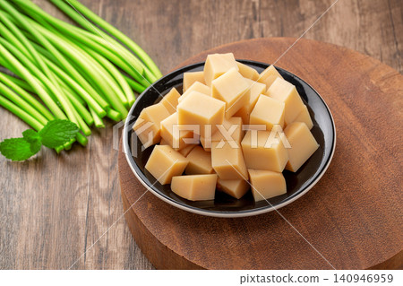 sliced Chinese Rice Tofu on Plate with Garlic Scapes Ready to Cook sliced Chinese Rice Tofu on Plate with Garlic Scapes Ready to Cook 140946959