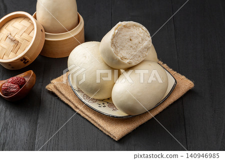 fluffy tall Chinese steamed buns arranged on a plate with a blue plaid napkin fluffy tall Chinese steamed buns arranged on a plate with a blue plaid napkin 140946985