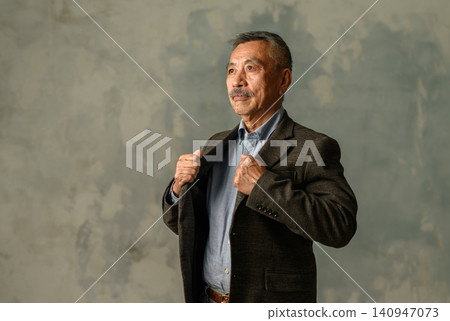 An elderly man adjusting his jacket. An elderly man adjusting his jacket. 140947073