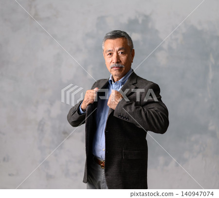 A man adjusts the collar of his jacket. A man adjusts the collar of his jacket. 140947074