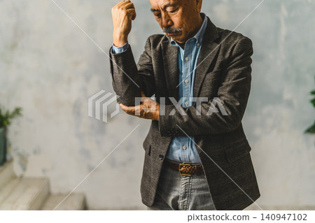 一位老人雙肘抱在胸前。 140947102
