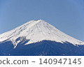 在湛藍的天空下，富士山的雪峰被染成一片白色，而林線以下的樹木也被積雪覆蓋，使森林山麓呈現出灰濛濛的色調。 140947145