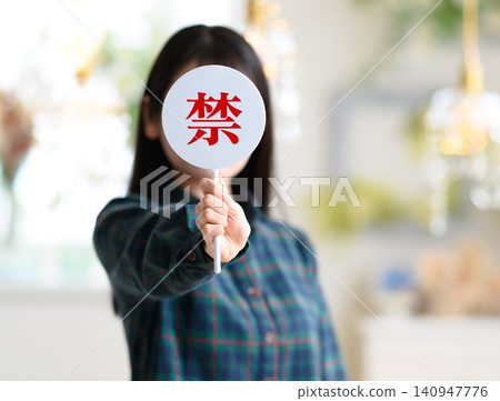 一名女子用「X」型手勢遮住臉。 140947776