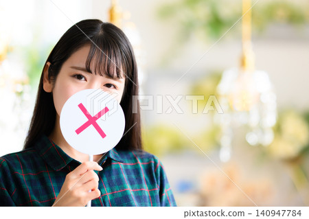 A woman hiding her face with an "X" mark. A woman hiding her face with an "X" mark. 140947784