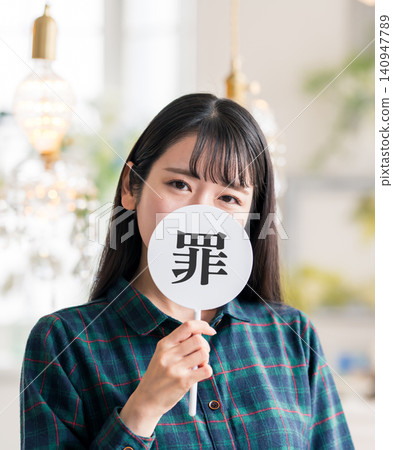A woman holding a fan with the word "sin" written on it. A woman holding a fan with the word "sin" written on it. 140947789