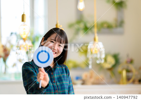 A young woman smiling and holding a bill A young woman smiling and holding a bill 140947792