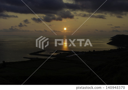 從沖繩縣宮古島浦小漁港看到的壯麗日出和照亮大海的光束。 從沖繩縣宮古島浦小漁港看到的壯麗日出和照亮大海的光束。 140948370