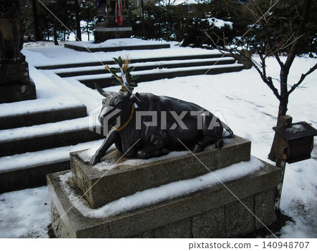 A statue of a cow in the snow 140948707