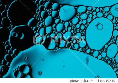 Macro scene shows turquoise bubbles, foam cells, and glossy droplets suspended in dark fluid, creating vivid organic texture for science or design backgrounds Macro scene shows turquoise bubbles, foam cells, and glossy droplets suspended in dark fluid, creating vivid organic texture for science or design backgrounds 140949239