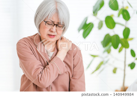 一位穿著睡衣、頭髮花白的老婦人，肩膀僵硬。 140949984