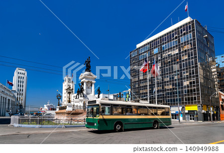 A vintage green trolleybus passes the Monument to the Heroes of Iquique at Plaza Sotomayor in Valparaiso, Chile. 140949988