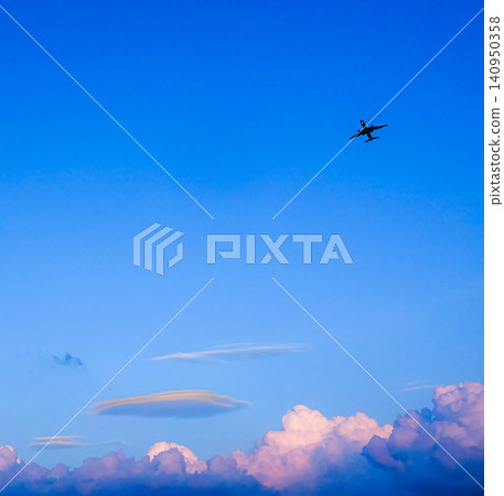 An airplane flying towards Asahikawa Airport in the twilight blue sky. An airplane flying towards Asahikawa Airport in the twilight blue sky. 140950358
