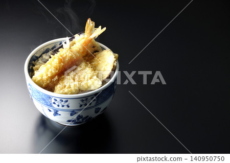 A single serving of piping hot tempura rice bowl photographed against a black background. A single serving of piping hot tempura rice bowl photographed against a black background. 140950750