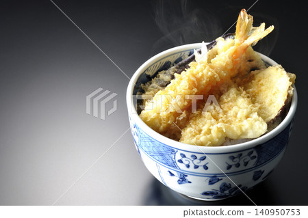 一碗熱氣騰騰的天婦羅飯，以黑色為背景拍攝。 140950753