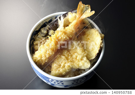 一碗熱氣騰騰的天婦羅飯,以黑色為背景拍攝。 一碗熱氣騰騰的天婦羅飯,以黑色為背景拍攝。 140950788