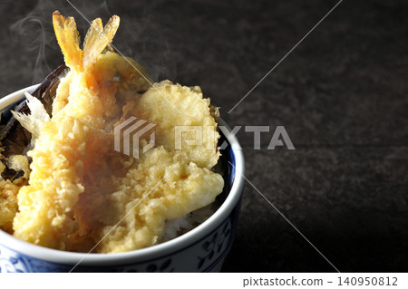 A piping hot tempura rice bowl containing shrimp, whiting, eggplant, and sweet potato. A piping hot tempura rice bowl containing shrimp, whiting, eggplant, and sweet potato. 140950812