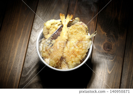 一碗熱氣騰騰的天婦羅飯,裡面有蝦子、鱈魚、茄子和地瓜。 一碗熱氣騰騰的天婦羅飯,裡面有蝦子、鱈魚、茄子和地瓜。 140950871