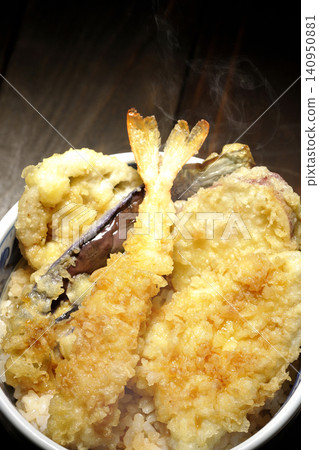 一碗熱氣騰騰的天婦羅飯,裡面有蝦子、鱈魚、茄子和地瓜。 一碗熱氣騰騰的天婦羅飯,裡面有蝦子、鱈魚、茄子和地瓜。 140950881