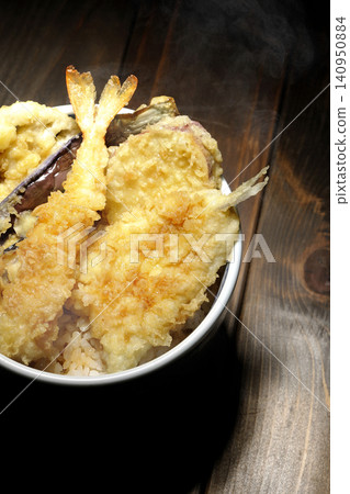 A piping hot tempura rice bowl containing shrimp, whiting, eggplant, and sweet potato. 140950884