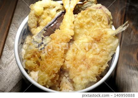 A piping hot tempura rice bowl containing shrimp, whiting, eggplant, and sweet potato. A piping hot tempura rice bowl containing shrimp, whiting, eggplant, and sweet potato. 140950888
