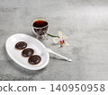 Cup of coffee and a plate with chocolate-dipped cookies. 140950958