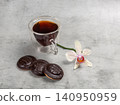 Cup of coffee and chocolate-dipped cookies with an orchid flower. 140950959