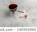 Cup of coffee and an orchid flower on the grey background. 140950960