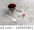 Cup of coffee with a spoon and an orchid flower. 140950961