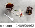 Cup of coffee and chocolate-dipped cookies with an orchid flower. 140950962