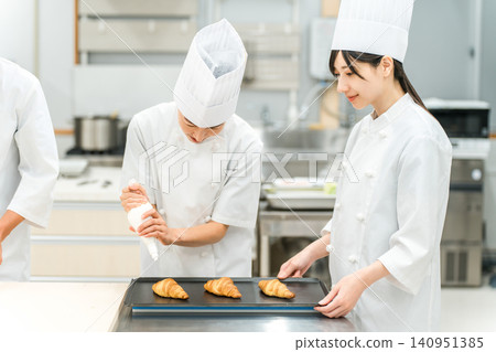 在廚房裡製作麵包、蛋糕和西式甜點的女性糕點師、蛋糕師和糖果工人。 140951385