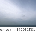 A minimalist landscape of a small boat against a sea covered in thick clouds. 140951581