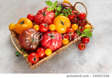 Heirloom tomatoes in a basket showing harvest variety Heirloom tomatoes in a basket showing harvest variety 140952388