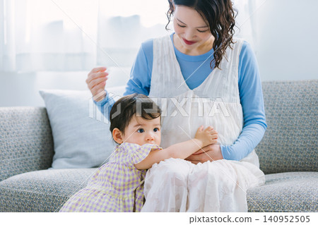 一歲女童撫摸懷孕母親的肚子。 一歲女童撫摸懷孕母親的肚子。 140952505