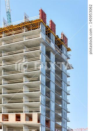 Construction of a tall building in an urban area with cranes and scaffolding Construction of a tall building in an urban area with cranes and scaffolding 140953062