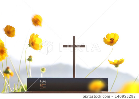 The cross of Jesus Christ and the holy Bible, beautiful flowers, and a background of worship and prayer. The cross of Jesus Christ and the holy Bible, beautiful flowers, and a background of worship and prayer. 140953292
