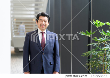 Asian businessman standing with a smile Asian businessman standing with a smile 140953335