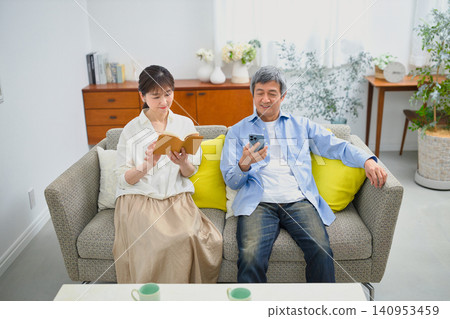 一對老年夫婦在沙發上放鬆休息。 140953459
