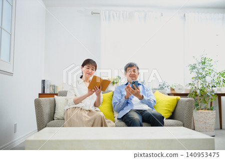 A senior couple relaxing on the sofa. A senior couple relaxing on the sofa. 140953475