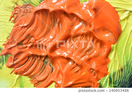 close-up of orange and green paint smears on a surface, creative art supplies for crafting projects, vibrant and dynamic visual resource for design and educational materials. 140953486