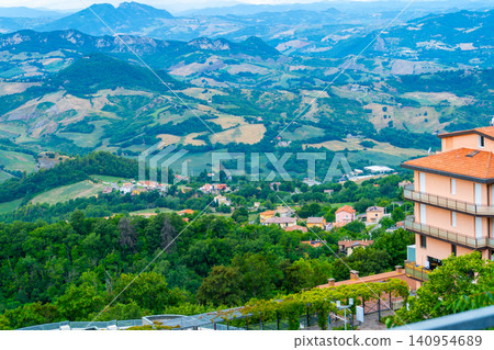 Republic of San Marino top view on the tiled roofs of the old town landscape. Architecture and nature. Mountains fields and green agricultural lane Republic of San Marino top view on the tiled roofs of the old town landscape. Architecture and nature. Mountains fields and green agricultural lane 140954689