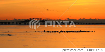 Orange Sunrise Over Great South Bay With Bridge and Frozen Water in Babylon Orange Sunrise Over Great South Bay With Bridge and Frozen Water in Babylon 140954718